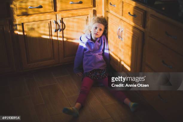 Girl Sitting on Kitchen Floor