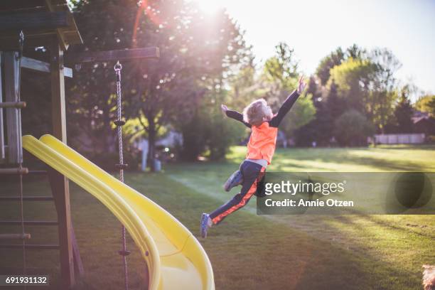 Little boy Leaping from a Jungle Gym Slide