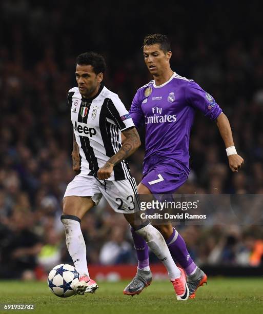 Dani Alves of Juventus is put under pressure from Cristiano Ronaldo of Real Madrid during the UEFA Champions League Final between Juventus and Real...