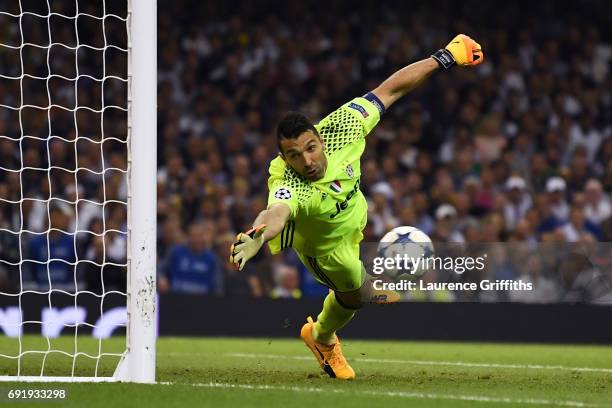 Gianluigi Buffon of Juventus dives but fails to stop Casemiro of Real Madrid shot from going in for Real Madrid second goal during the UEFA Champions...