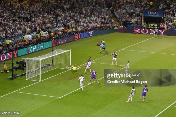 Cristiano Ronaldo of Real Madrid scores his sides third goal past Gianluigi Buffon of Juventus during the UEFA Champions League Final between...