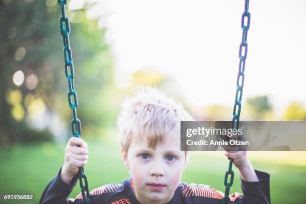 boy on swing - annie otzen stock pictures, royalty-free photos & images