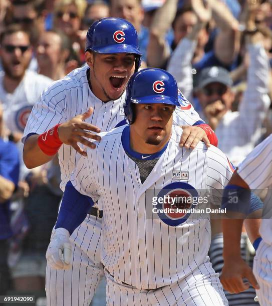 Willson Contreras of the Chicago Cubs jumps on the back of teammate Kyle Schwarber after Schwarber hit a grand slam home run in the 7th inning...
