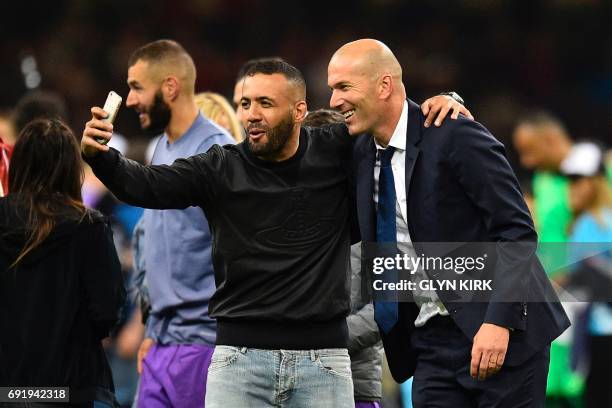 Real Madrid's French coach Zinedine Zidane poses for a selfie during the UEFA Champions League final football match between Juventus and Real Madrid...