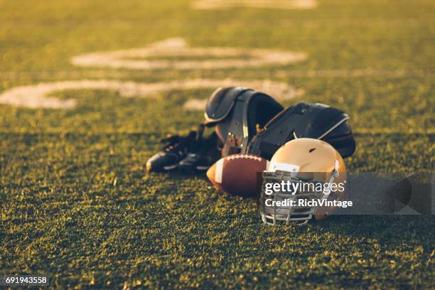 gold football helmet on field - football season stock pictures, royalty-free photos & images