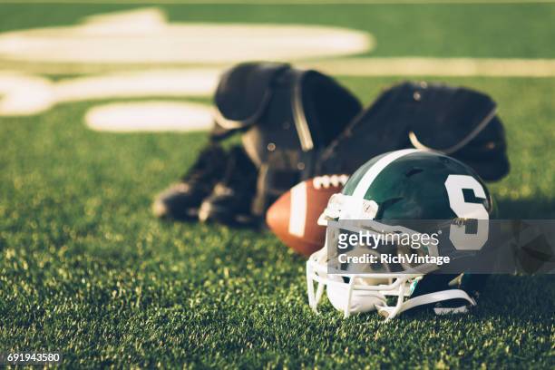 grüne football helm auf feld - michigan state university football stock-fotos und bilder