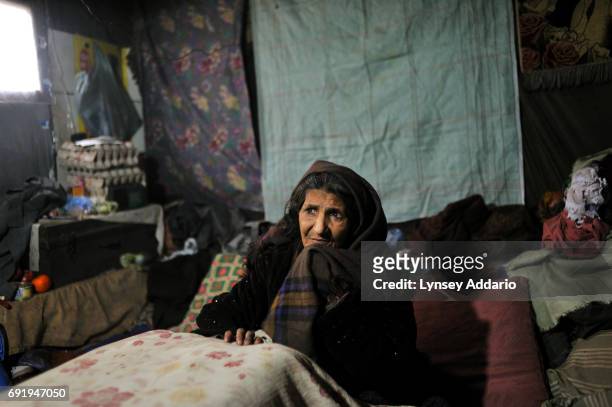 Shirinjan, about 50, sits after smoking heroin in the hovel she lives in with her boyfriend in Kabul, Afghanistan, December 18, 2008. Shirinjan used...