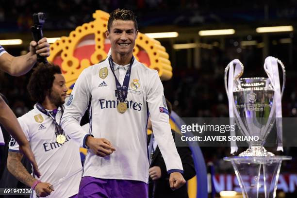 Real Madrid's Portuguese striker Cristiano Ronaldo celebrates next to the trophy after Real Madrid won the UEFA Champions League final football match...