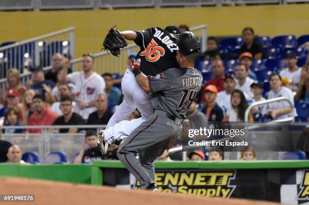 Edinson Volquez of the Miami Marlins and Reymond Fuentes of the Arizona Diamondbacks collide at first base during the first inning at Marlins Park on...