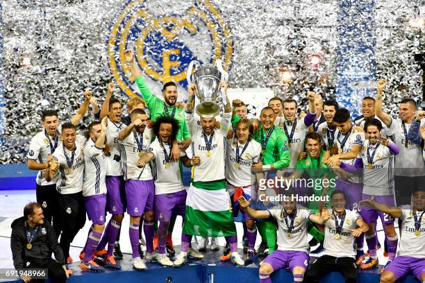In this handout image provided by UEFA, Sergio Ramos of Real Madrid lifts The Champions League trophy after the UEFA Champions League Final between...