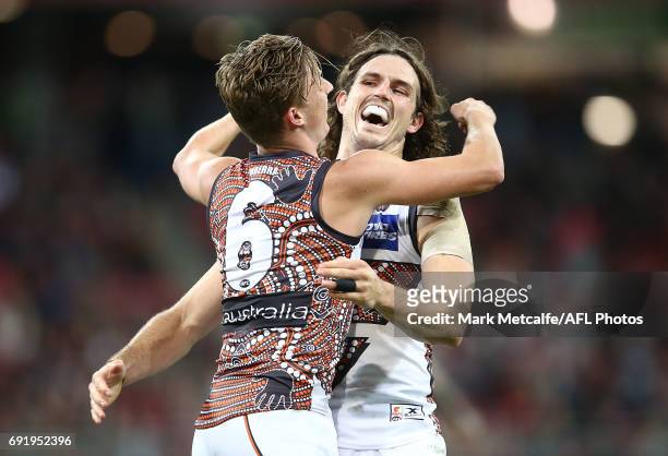 Lachie Whitfield of the Giants celebrates with team mate Phil Davis after kicking a goal during the round 11 AFL match between the Greater Western...
