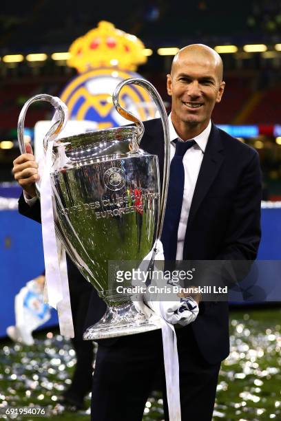 Real Madrid coach Zinedine Zidane poses with the trophy following the UEFA Champions League Final match between Juventus and Real Madrid at the...