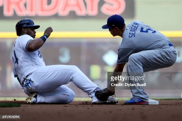 Corey Seager of the Los Angeles Dodgers tags out Jesus Aguilar of the Milwaukee Brewers at second base during a pickoff in the first inning at Miller...