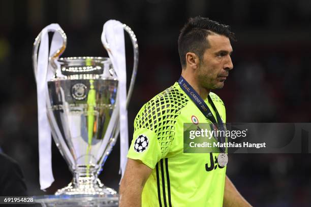 Gianluigi Buffon of Juventus walks past the Champions League Trophy after the UEFA Champions League Final between Juventus and Real Madrid at...