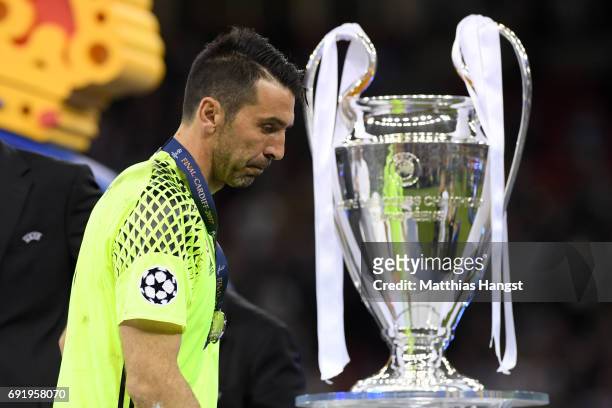 Gianluigi Buffon of Juventus walks past the Champions League trophy after the UEFA Champions League Final between Juventus and Real Madrid at...