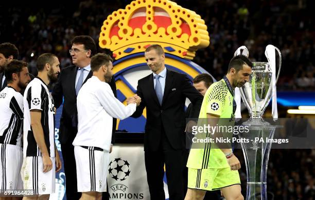 Juventus goalkeeper Gianluigi Buffon appears dejected as UEFA President Aleksander Ceferin shakes hands with Andrea Barzagli after the final whistle...