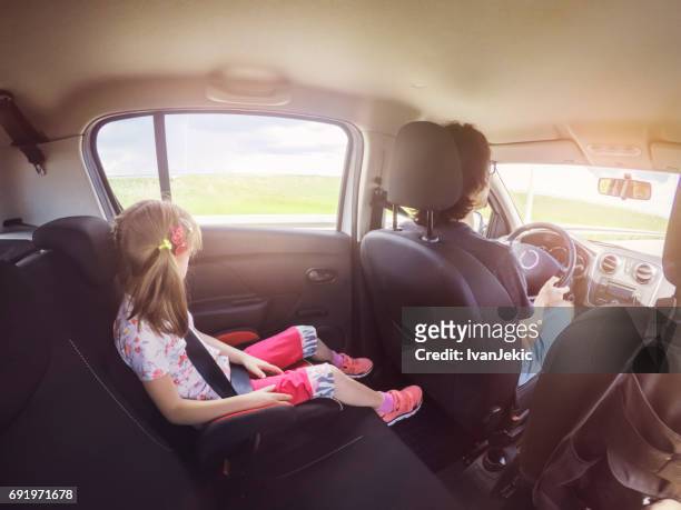 little girl driving in the car in the backseat - car point of view stock pictures, royalty-free photos & images