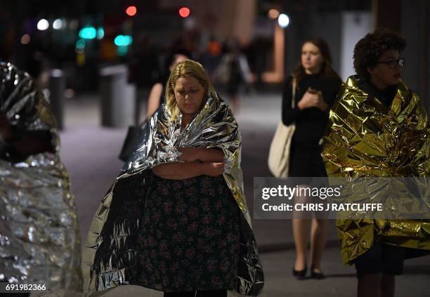 Members of the public, wrapped in emergency blankets leave the scene of a terror attack on London Bridge in central London on June 3, 2017. Armed...