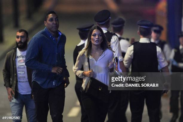 Members of the public leave the scene of a terror attack on London Bridge in central London on June 3, 2017. Armed police opened fire during what...