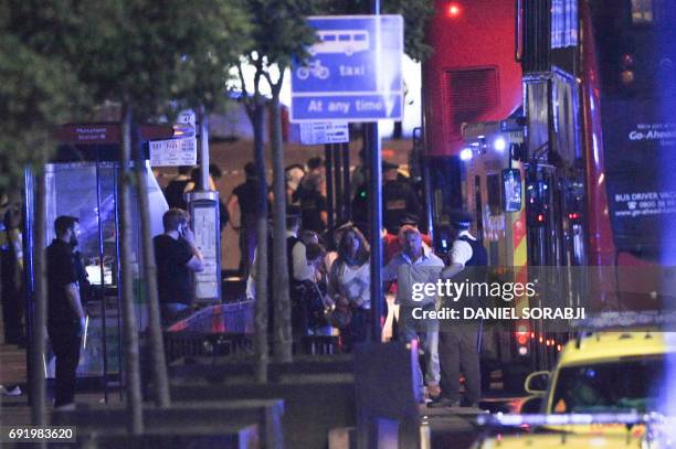 Police escort members of the public at the scene of a terror attack on London Bridge in central London on June 3, 2017. Armed police fired shots...