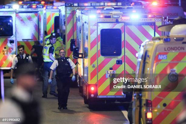 Members of the emergency services attend to persons injured in an apparent terror attack on London Bridge in central London on June 3, 2017. Armed...