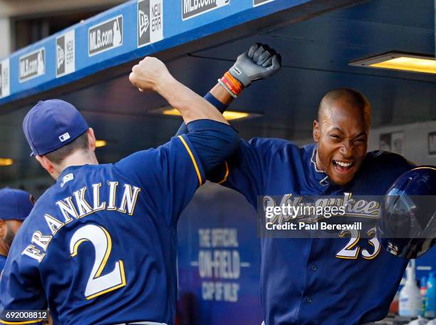 Nick Franklin and Keon Broxton of the Milwaukee Brewers celebrate in the dugout after Broxton hit a home run in the second inning in an MLB baseball...