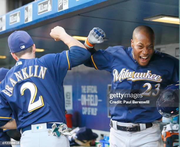 Nick Franklin and Keon Broxton of the Milwaukee Brewers celebrate in the dugout after Broxton hit a home run in the second inning in an MLB baseball...