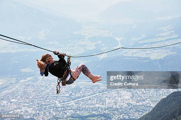 highline walker hanging on tightrope, innsbruck, tyrol, austria - woman tightrope stock pictures, royalty-free photos & images