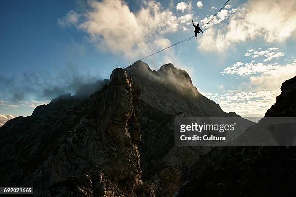 highline walker balancing on tightrope, innsbruck, tyrol, austria - drahtseilakt stock-fotos und bilder