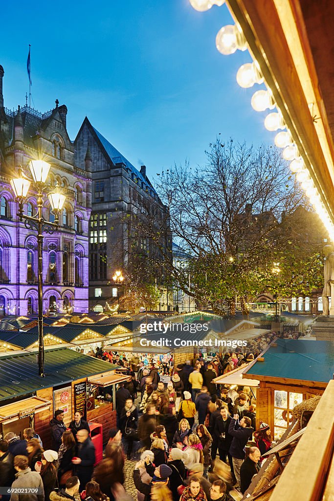 Christmas market illuminated at night, Albert Square, Manchester, UK