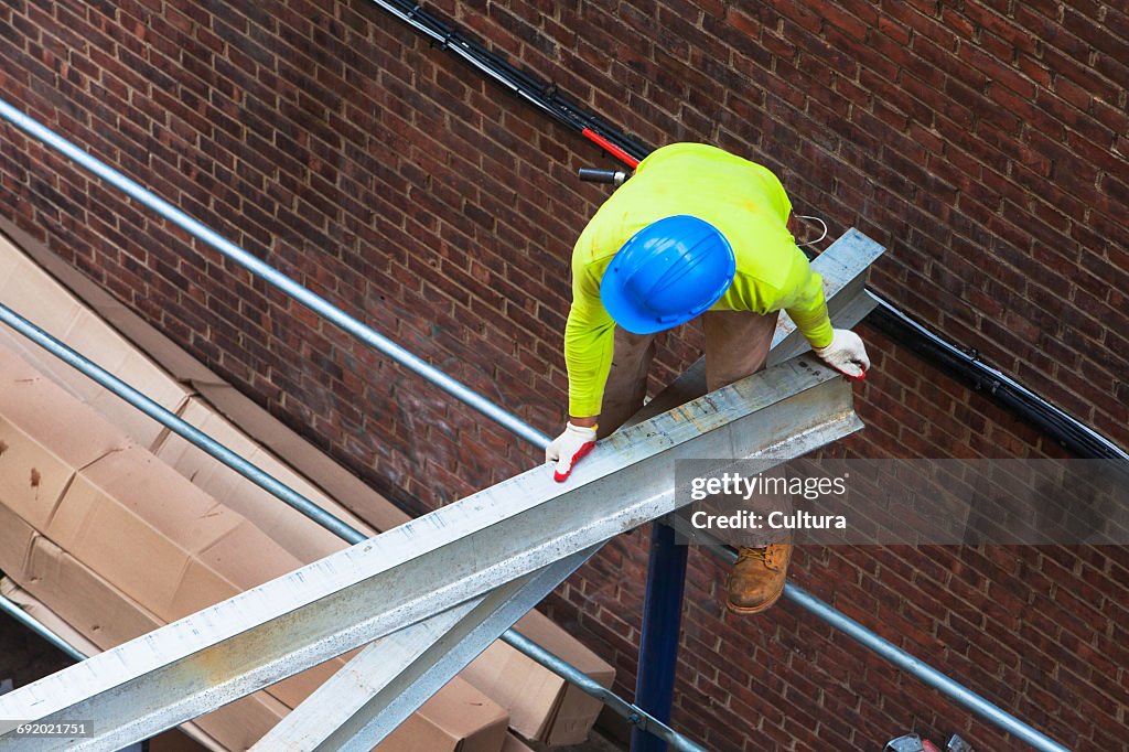 High angle view of labourer moving girder at construction site