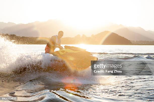 man riding jet ski on lake, beijing, china - jet boat fotografías e imágenes de stock