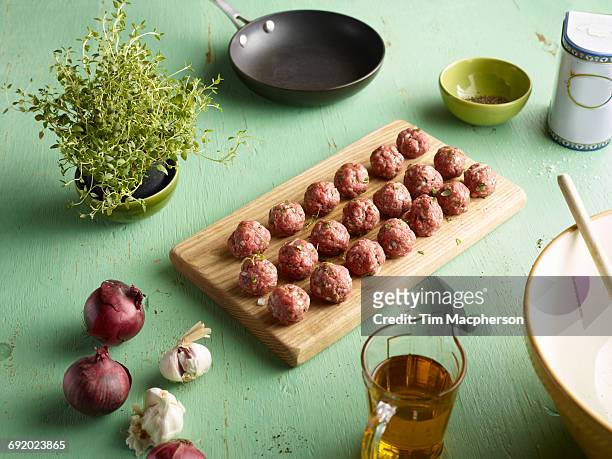 rows of raw prepared greek meatballs on chopping board - halstock stock pictures, royalty-free photos & images