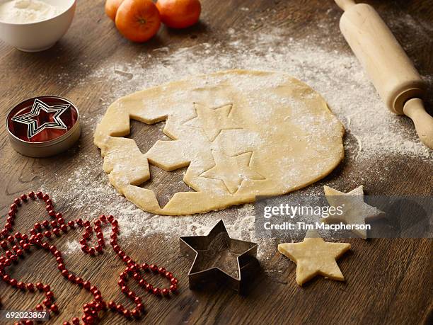 table with christmas star biscuit dough and rolling pin - halstock stock-fotos und bilder
