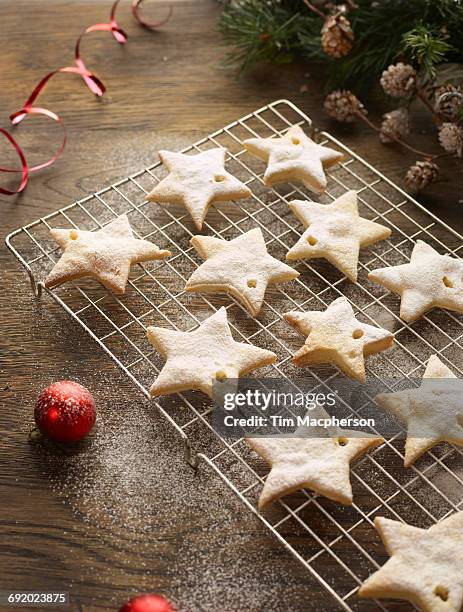 christmas star biscuits on cooling rack - halstock stock pictures, royalty-free photos & images