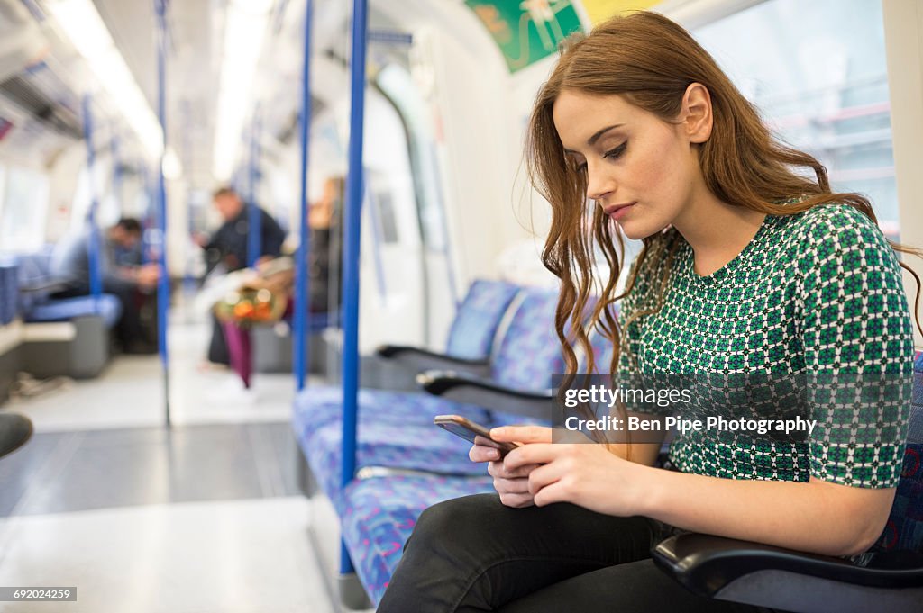 Woman on train looking at smartphone