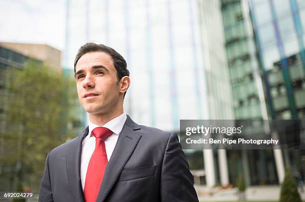 portrait of businessman looking away - roter anzug stock-fotos und bilder