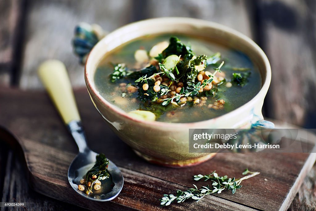 Bowl of broth on wooden cutting board