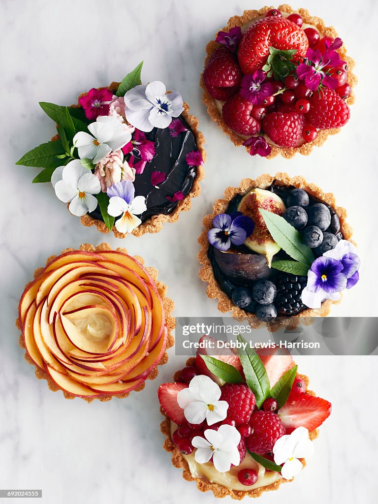 Display of variety of tart, fruit and flowers