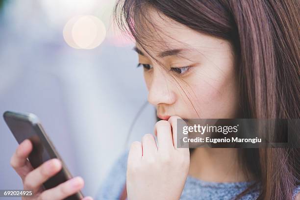 close up of young woman reading smartphone - 見つめる ストックフォトと画像