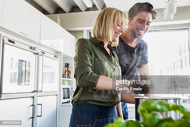 couple in kitchen cooking - kochen stock-fotos und bilder