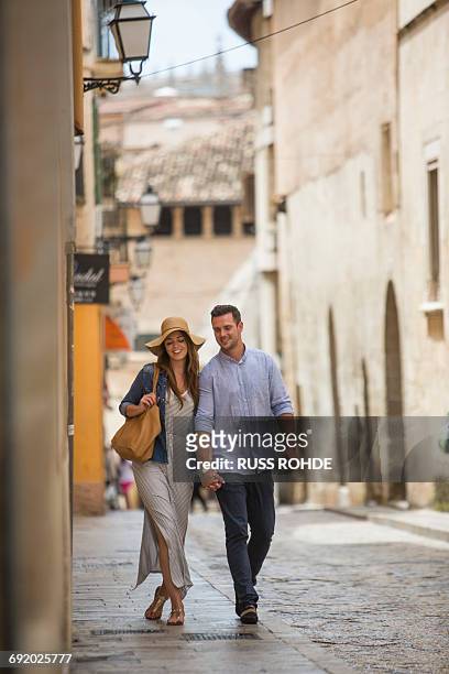 couple walking on street, palma de mallorca, spain - palma maiorca stockfoto's en -beelden