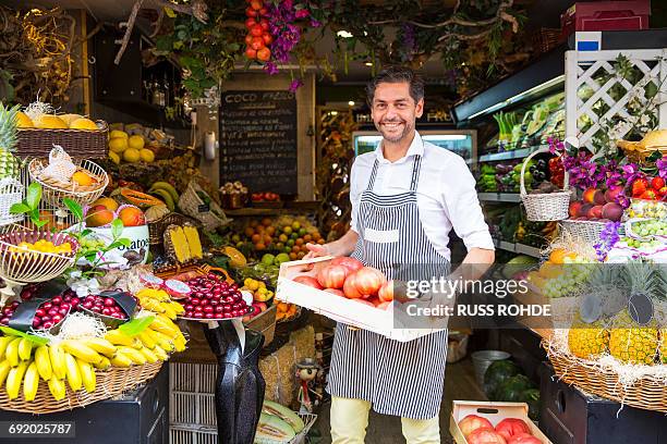 fruiterer carrying tray of fruits in shop, palma de mallorca, spain - gemüseladen stock-fotos und bilder