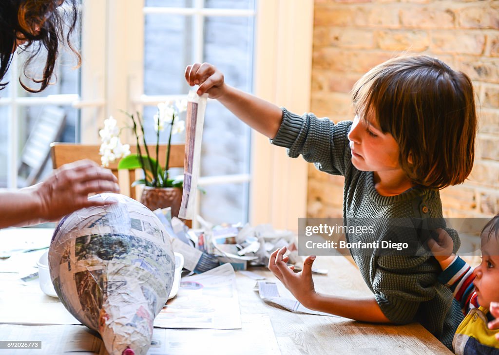 Child and mother playing with papier mache