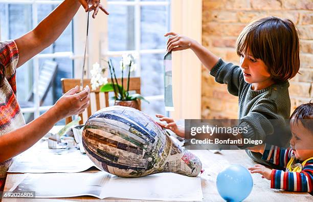 child and mother playing with papier mache - papier 個照片及圖片檔