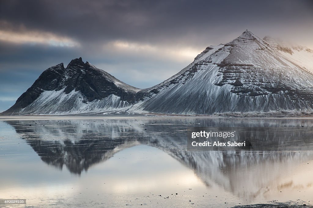 Reflection of mountains on the ocean during sunset in Vatnajokull National Park, Iceland.