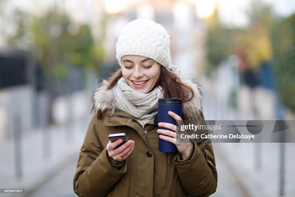 A young woman with a smartphone in the street