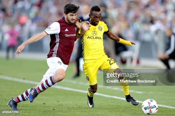 Eric Miller of the Colorado Rapids battles for the ball against Harrison Afful of Columbus Crew SC at Dick's Sporting Goods Park on June 3, 2017 in...