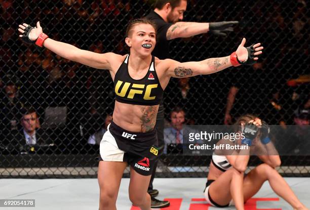 Claudia Gadelha of Brazil celebrates after her submission victory over Karolina Kowalkiewicz of Poland in their womens strawweight bout during the...