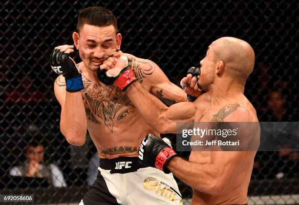 Jose Aldo of Brazil punches Max Holloway in their UFC featherweight championship bout during the UFC 212 event at Jeunesse Arena on June 3, 2017 in...